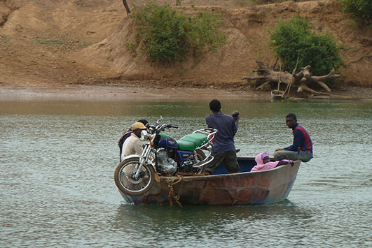 Ein Motorrad wird in einem kleinen Boot transportiert